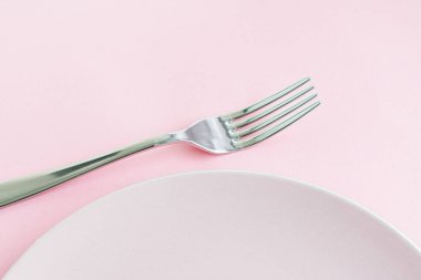 Boş tabak ve çatal bıçak seti pembe arka planda, en iyi sofra takımı şef masa dekorasyonu ve menü markalaşması için