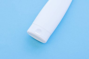 Mavi arkaplanda ürün modeli olarak boş etiket kozmetik kutu şişesi