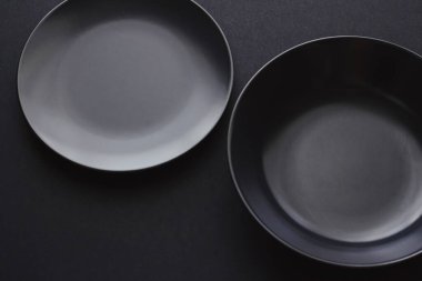 Siyah arka planda boş tabaklar, bayram yemeği için kaliteli bulaşık takımı, minimal tasarım ve diyet