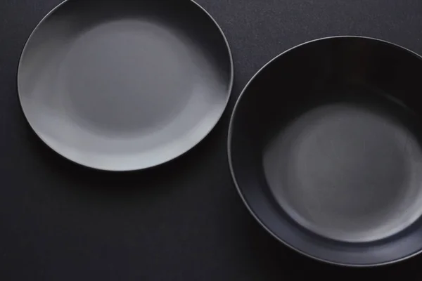 Puste talerze na czarnym tle, naczynia premium na świąteczną kolację, minimalistyczny design i dieta — Zdjęcie stockowe