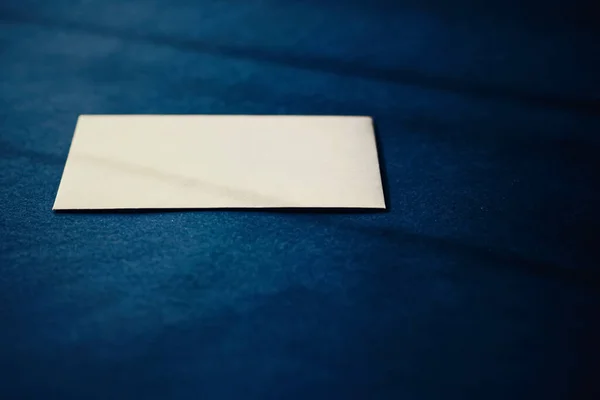 Pusta beżowa kartka papierowa na niebieskim tle, makieta biznesowa i luksusowa marka — Zdjęcie stockowe