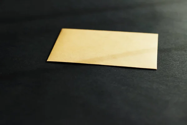 Blank golden paper card on black background, business and luxury brand identity mockup