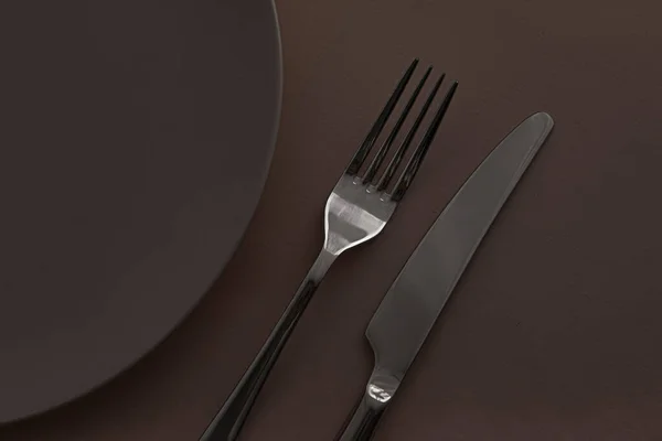 Piatto vuoto e posate come mockup impostato su sfondo marrone scuro, stoviglie superiori per l'arredamento della tavola dello chef e il marchio del menu — Foto Stock