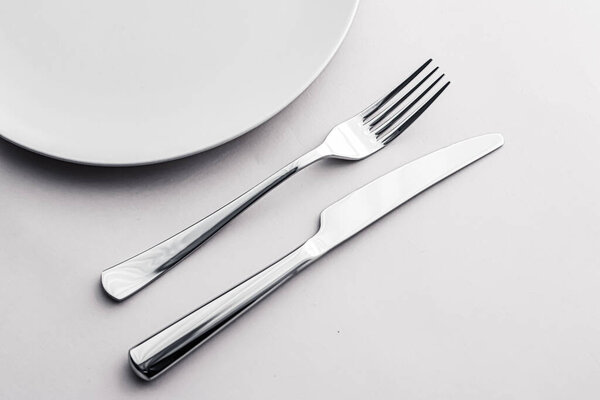 Empty plate and cutlery as mockup set on white background, top tableware for chef table decor and menu branding