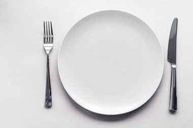 Boş tabak ve çatal bıçak seti beyaz arka planda, şef masa dekorasyonu ve menü markalaşması için en üst masa takımı