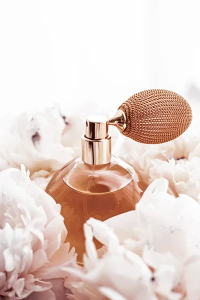 Butelka zapachowa jako produkt perfum vintage na tle kwiatów piwonii, perfum reklamowych i marki piękna — Zdjęcie stockowe