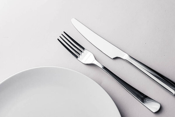 Empty plate and cutlery as mockup set on white background, top tableware for chef table decor and menu branding