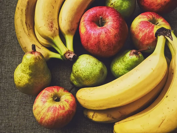 Ekologiska äpplen, päron och bananer på rustik linne bakgrund — Stockfoto