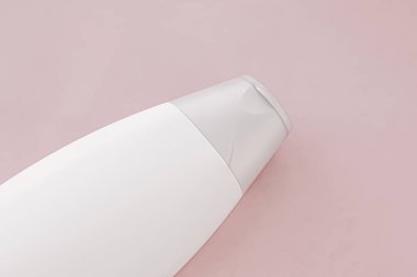Pembe arka planda boş etiket şampuan şişesi veya duş jeli, güzellik ürünü ve vücut bakım ürünleri