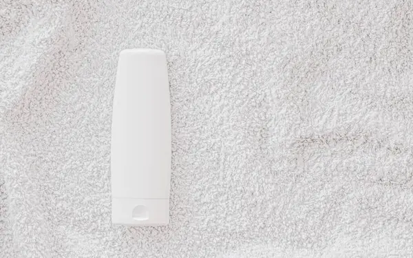 Etiqueta en blanco botella de envase cosmético como maqueta del producto sobre fondo de toalla blanca — Foto de Stock