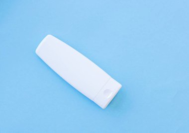 Mavi arkaplanda ürün modeli olarak boş etiket kozmetik kutu şişesi