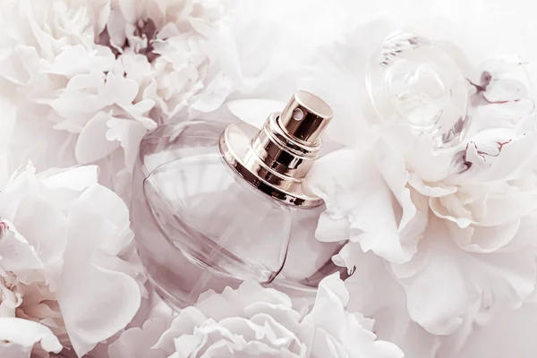 Шикарная бутылка аромата как роскошный парфюмерный продукт на фоне пионских цветов, парфюмерной рекламы и брендинга красоты — стоковое фото