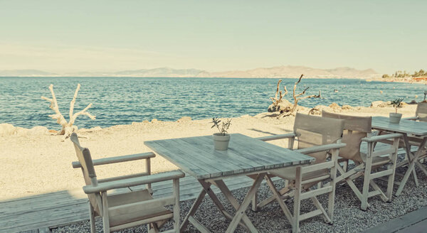 Empty restaurant by the Aegean sea and cruise boat, travel and nature