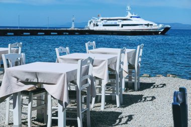 Ege Denizi kıyısındaki boş bir restoran ve gemi, seyahat ve doğa.