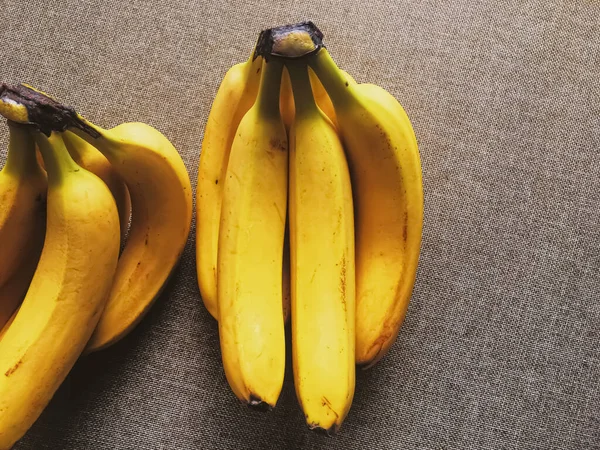 Biologische bananen op rustieke linnen achtergrond — Stockfoto