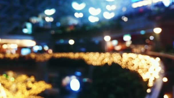 Vista desenfocada de la decoración de las vacaciones de Navidad dentro de un moderno centro comercial, fondo e iluminación — Vídeos de Stock