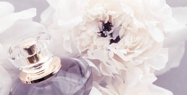 Eflatun parfüm şişesi fonda şakayık çiçekleri, parfüm reklamı ve güzellik markası olan lüks parfüm ürünü.