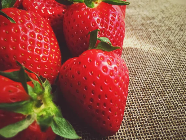 Bio-Erdbeeren auf rustikalem Leinenhintergrund — Stockfoto