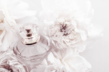 Şık parfüm şişesi, fonda şakayık çiçekleri, parfüm reklamı ve güzellik markası olan lüks bir parfüm ürünü.