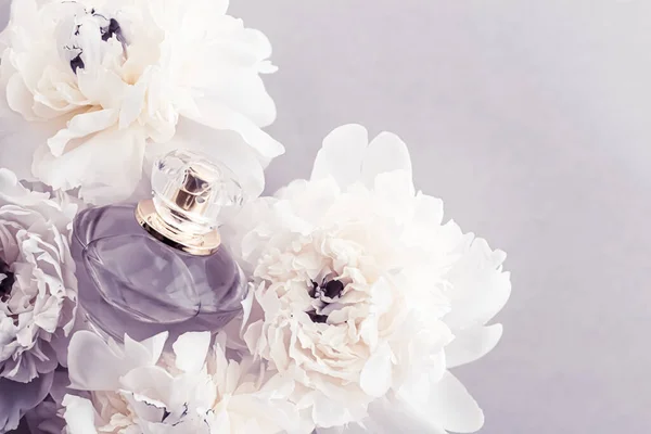 Flacon de parfum violet comme produit de parfum de luxe sur fond de fleurs de pivoine, annonce de parfum et marque de beauté — Photo