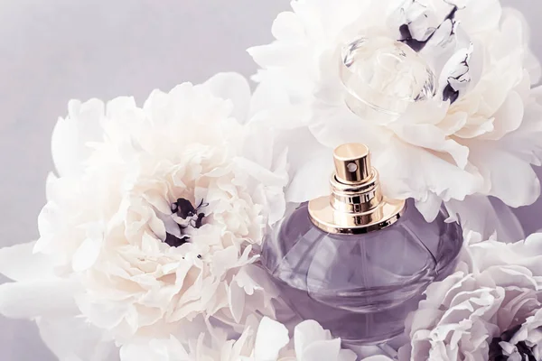 Fioletowa butelka zapachowa jako luksusowy produkt perfumeryjny na tle piwonii, perfum reklamowych i marki urody — Zdjęcie stockowe