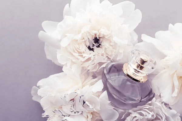 Garrafa de fragrância violeta como produto de perfume de luxo no fundo de flores de peônia, anúncio de parfum e marca de beleza — Fotografia de Stock