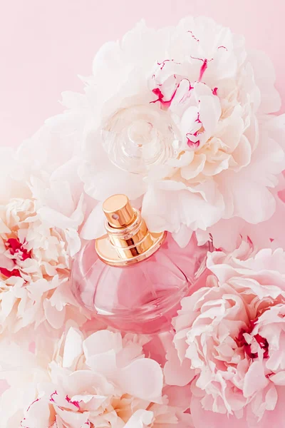 Бутылка аромата люкс в качестве девчачьего парфюмерного продукта на фоне цветов пиона, парфюмерной рекламы и брендинга красоты — стоковое фото