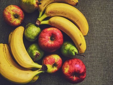 Kırsal keten zeminde organik elmalar, armutlar ve muzlar