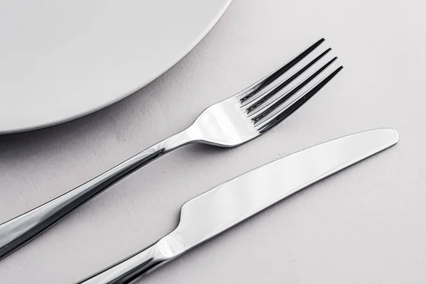 Пустая тарелка и столовые приборы как макет, установленный на белом фоне, верхняя посуда для декора стола шеф-повара и брендинга меню — стоковое фото