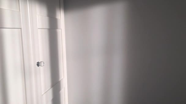 Drzwi białe eleganckie szafy z kryształowymi uchwytami w pokoju o zachodzie słońca, meble i wystrój wnętrz — Wideo stockowe