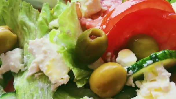 Ensalada de verduras frescas con queso feta, lechuga, pepinos, tomates y aceitunas, comida vegetariana saludable, cocina mediterránea y comida — Vídeos de Stock