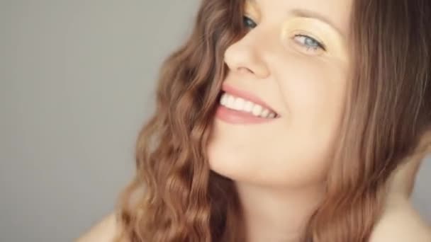 Mulher feliz sorrindo e rindo, cabelo ondulado marrom longo, maquiagem natural e dentes brancos saudáveis, rosto e beleza — Vídeo de Stock