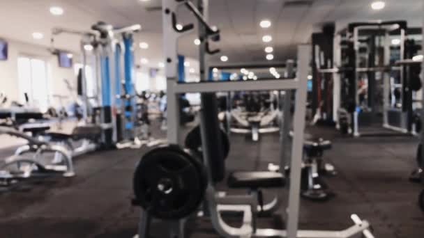 Spor salonunun sağlıklı yaşam tarzı ve vücut geliştirme için gerekli ekipman ve spor malzemeleriyle odaklı olmayan görüntüsü. — Stok video