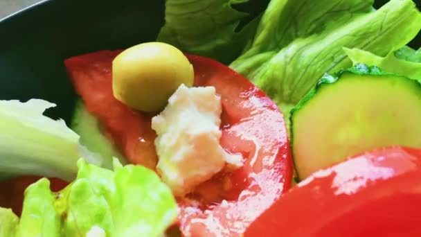Färsk grönsakssallad med fetaost, sallad, gurka, tomater och oliver, hälsosam vegetarisk kost, medelhavskök och mat — Stockvideo
