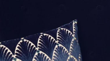 Kadife koltukta geometrik desenli bir döşek, ev dekorasyonu olarak koyu mavi yastık, lüks mobilyalar ve iç tasarım.