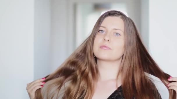 Retrato de uma jovem mulher com cabelo castanho longo e saudável, rotina de cuidados com o cabelo para penteado suave, brilhante, natural, saúde e beleza — Vídeo de Stock