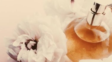 Şakayık çiçekli klasik parfüm şişesi, lüks kozmetik, retro moda ve güzellik ürünleri arka planında şık bir koku.