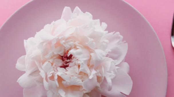 Ροζ τραπεζομάντηλο με παιώνια λουλούδια στο πιάτο και ασημικά για δείπνο πολυτελείας, γαμήλια ή εορταστική εκδήλωση γενεθλίων — Αρχείο Βίντεο