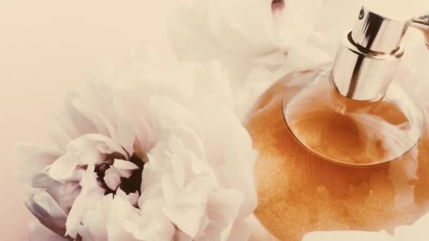 Botella de perfume vintage con flores de peonía, aroma de fragancia elegante como cosmético de lujo, moda retro y fondo de producto de belleza — Vídeo de stock