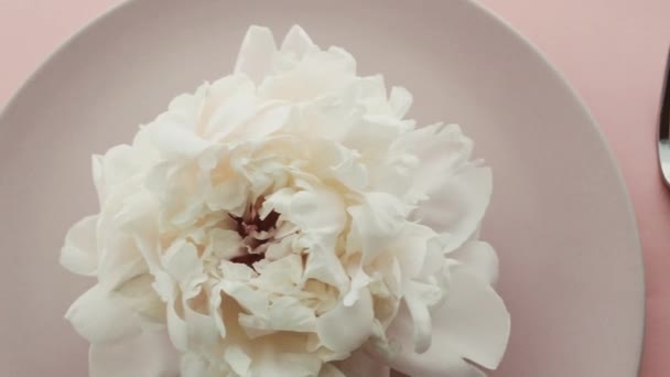 Μπεζ σκηνικό τραπεζιού με παιώνια λουλούδια στο πιάτο και ασημικά για πολυτελή δείπνο, γαμήλια ή εορταστική εκδήλωση γενεθλίων — Αρχείο Βίντεο