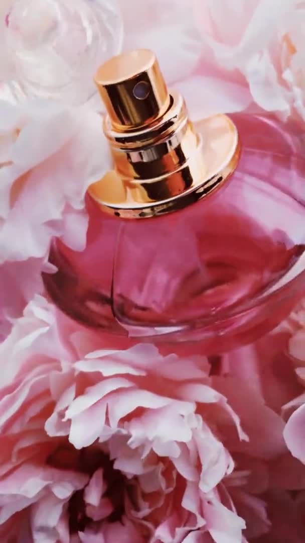 Flacon de parfum rose avec des fleurs pivoines, parfum chic comme fond cosmétique de luxe, mode et produit de beauté — Video