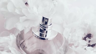Şakayık çiçekli beyaz parfüm şişesi lüks kozmetik, moda ve güzellik ürünleri arka planında şık bir koku.