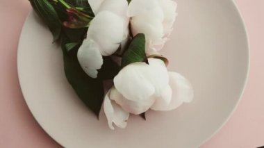 Tabağında şakayık çiçekleri olan bej masa seti ve lüks yemek, düğün ya da doğum günü kutlaması için çatal bıçak takımı.