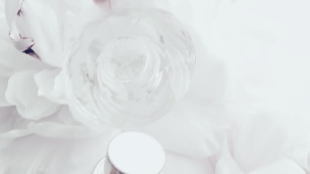 Frasco de perfume blanco con flores de peonía, aroma de fragancia elegante como cosmético de lujo, fondo de productos de moda y belleza — Vídeos de Stock
