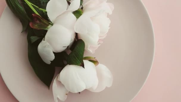 Beige Tischdekoration mit Pfingstrosenblumen auf Teller und Besteck für luxuriöses Dinner, Hochzeit oder Geburtstagsfeier — Stockvideo
