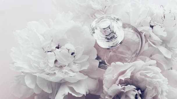 Frasco de perfume branco com flores de peônia, perfume de fragrância chique como cosméticos de luxo, moda e fundo do produto de beleza — Vídeo de Stock