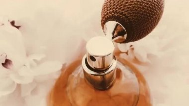 Şakayık çiçekli klasik parfüm şişesi, lüks kozmetik, retro moda ve güzellik ürünleri arka planında şık bir koku.