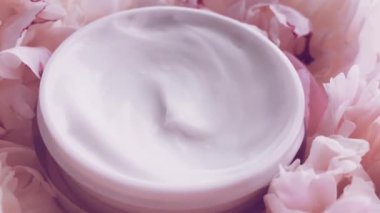 Mineral yüz kremi kavanozu ve şakayık çiçekleri, lüks kozmetik ürünleri, güzellik ürünleri ve cilt bakımı için temiz nemlendirici.