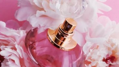 Şakayık çiçekli pembe parfüm şişesi lüks kozmetik, moda ve güzellik ürünleri arka planında şık bir koku.