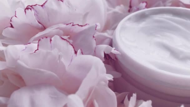 Mineral yüz kremi kavanozu ve şakayık çiçekleri, lüks kozmetik ürünleri, güzellik ürünleri ve cilt bakımı için temiz nemlendirici. — Stok video
